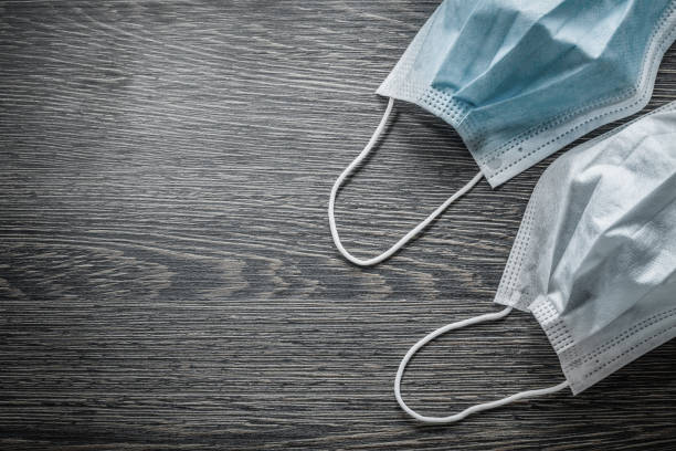 istock Sterile face masks on vintage wooden board copy space 875100380
