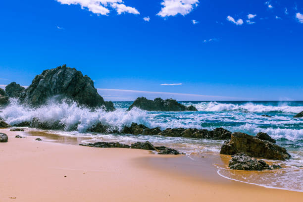 istock Ocean waves breaking on beautiful rugged rocks on the beach on bright sunny day 875100748
