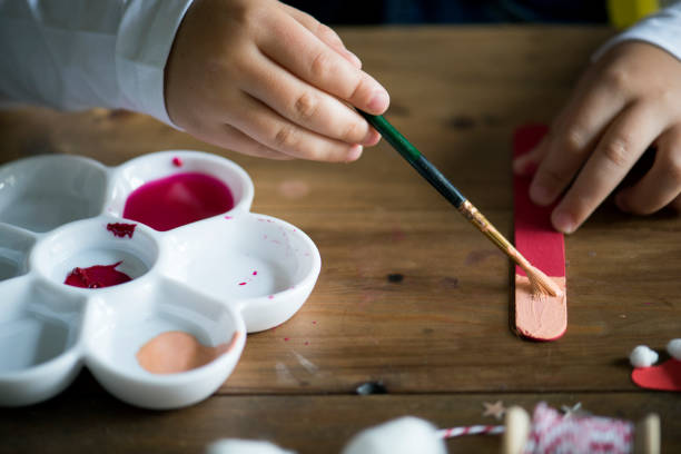 Kid painting on an ice cream stick