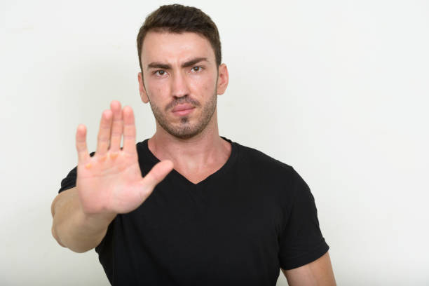 istock Young handsome man wearing black shirt against white background 875110302