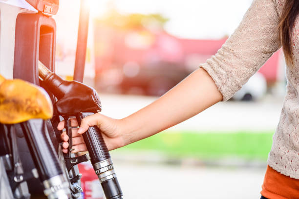 primer plano de la mano de la mujer con una bomba de combustible en una estación. - tank top fotografías e imágenes de stock