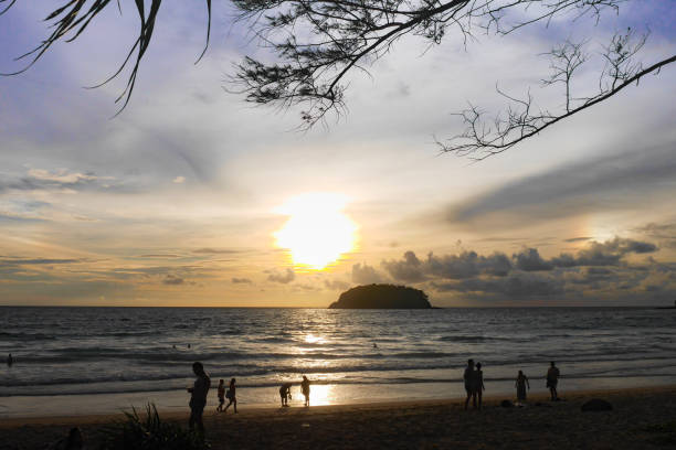 istock Phuket,Thailand - September 13, 2017-  At Kata Beach, tourists doing activities , such as sunbathing, reading, swimming, taking pictures, watching the sunset. The island is highlight with cloudy sky. 875120836
