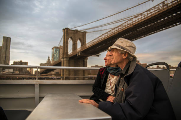 старшая пара, путешествующая по манхэттену, нью-йорк. верховая езда на пароме в ист-ривер - senior adult new york state new york city active seniors стоковые фото и изображения