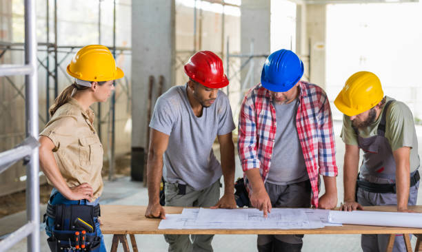 istock Group Of Contstuction Workers Reviewing Plans 875125136