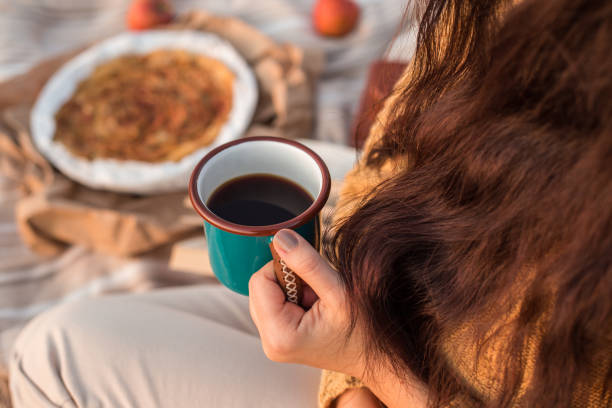 istock Cozy autumn picnic. Female hand holding a mug with tea 875130548