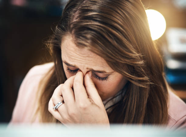 istock Blonde office worker rubs eyes, frowning 875135162