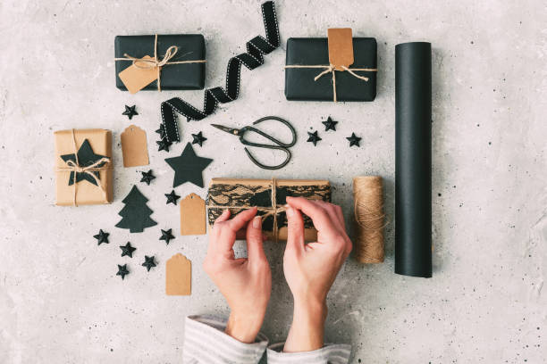 beautiful female hands are packed christmas gift in paper, rope. gift box in brown kraft paper tied with string. - string package brown paper imagens e fotografias de stock