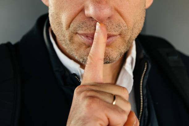 istock Attractive unshaved adult man with finger on lips making silence 875144560