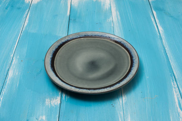 istock Round plate on blue wooden table with perspective 875144622