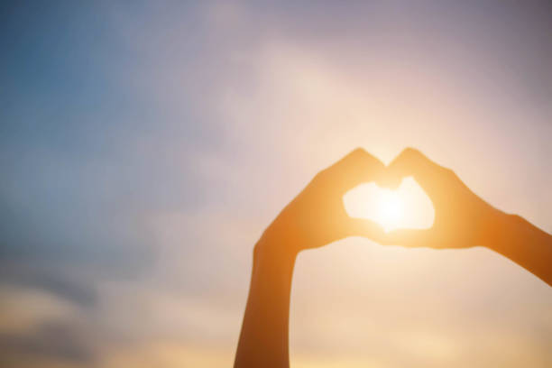 istock hands forming a heart shape with sunset silhouette 875147310