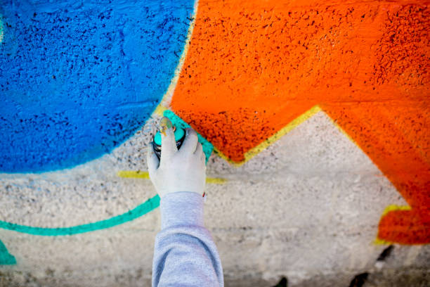 istock Late Teen Graffiti Artist Drawing Graffiti on Wall 875160936