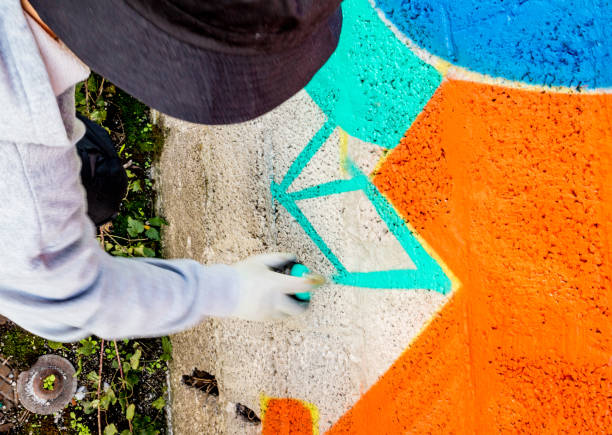 istock Late Teen Graffiti Artist Drawing Graffiti on Wall 875160952