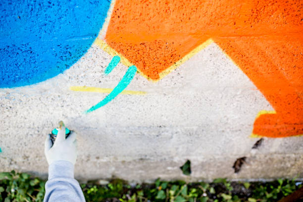 istock Late Teen Graffiti Artist Drawing Graffiti on Wall 875160956