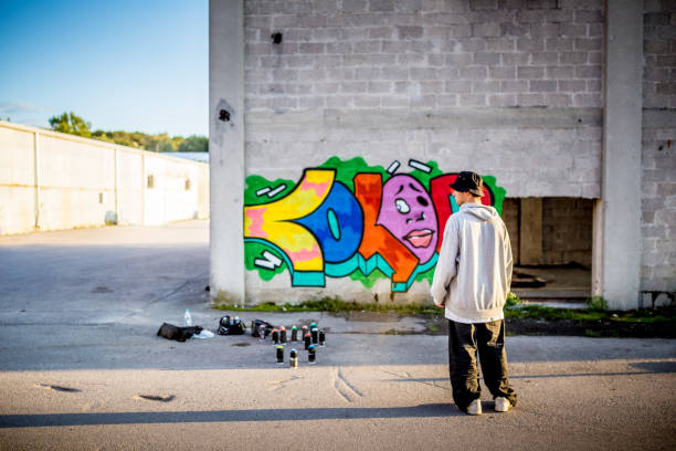 istock Late Teen Graffiti Artist Looking at his Graffiti 875161056