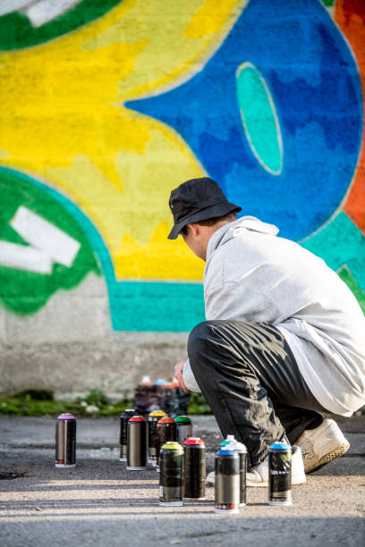 istock Graffiti Artist Picking Up Spray Cans 875161140