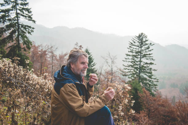 istock Senior Man Eating Bread in Autumnal Forest, Europe 875164806