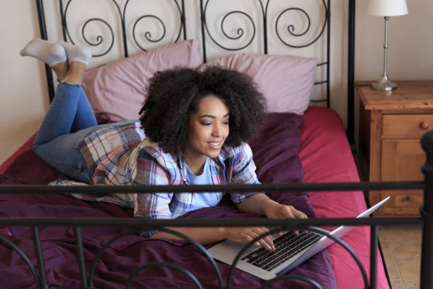 istock Woman lying in bed and using laptop at home 875168244