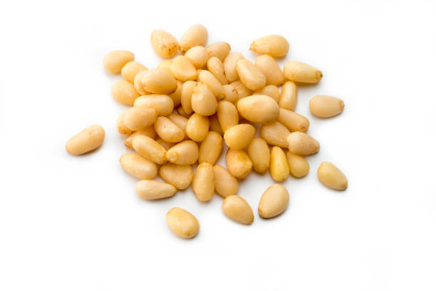 Nuts: high angle view Pile of white pine nuts on a white background