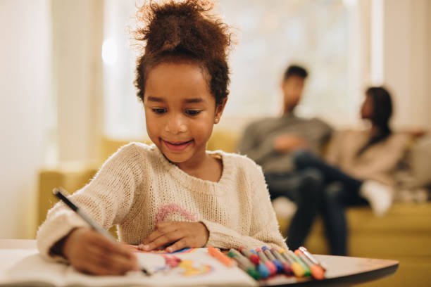 istock Cute African American girl having fun while drawing at home. 875169288