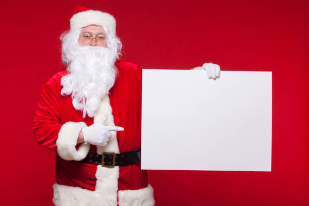 istock Santa Claus pointing in blank advertisement banner isolated on red background with copy space 875172044