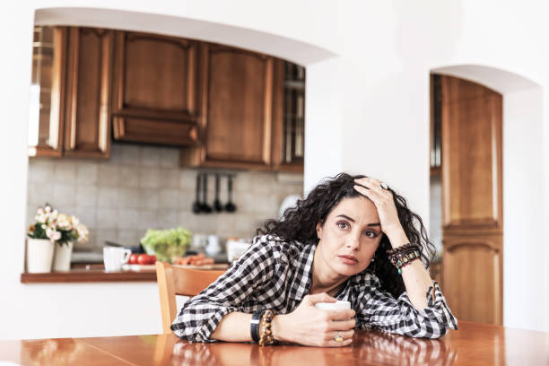 istock Woman sitting home alone 875176282