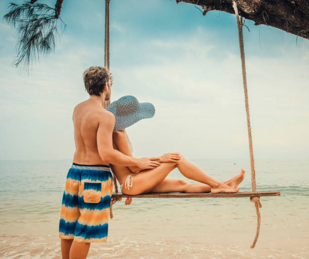 istock Couple sitting at rope swings 875182540