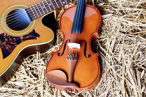 Guitarra acústica y violín en la paja: tiempo de la música de país photo