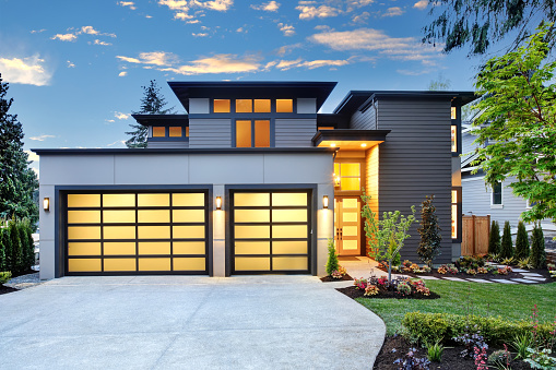 Beautiful exterior of contemporary home with two car garage spaces at sunset. Northwest, USA