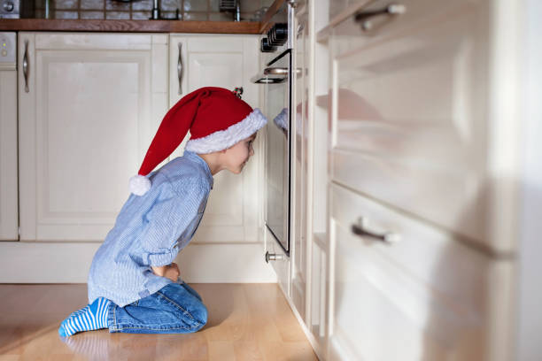 istock Curious little boy, watching ginger bread cookies in the oven 875201870