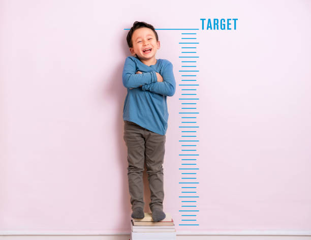 Child measuring his height Child measuring his height on wall. He is growing up so fast. boy height measure stock pictures, royalty-free photos & images