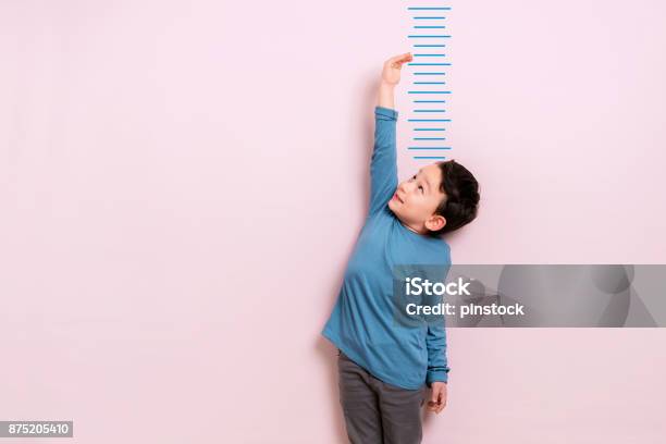 Child Measuring His Height Stock Photo - Download Image Now - Child, Growth, Measuring