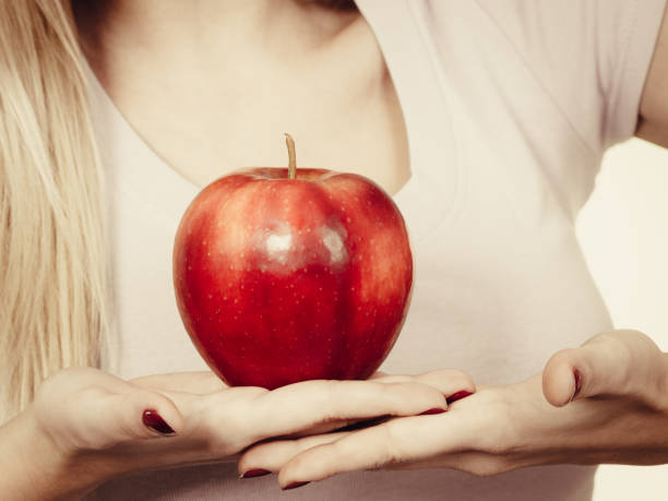 istock Woman hand holding delicious red apple 875206102