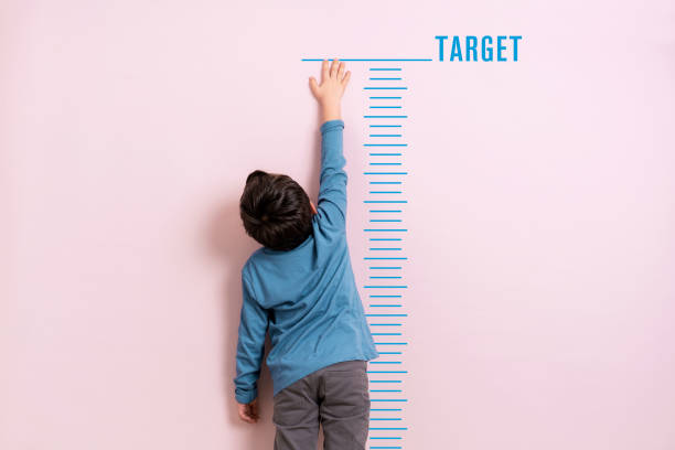Child measuring his height stock photo