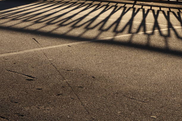 istock Guardrail Shadow on Icy Asphalt Road Surface. Urban Street Background 875218118
