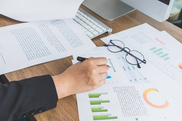 istock Business woman reading and checking graph documents on her desk, business concept 875219002