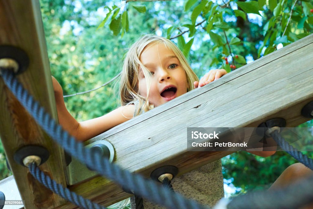 Porträt eines schönen Mädchens auf einem Seilpark unter den Bäumen. - Lizenzfrei Kinderspielplatz Stock-Foto