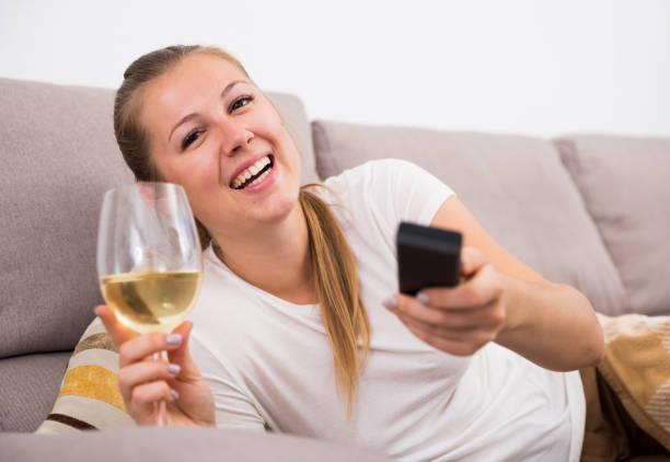 istock Girl is resting with wine and watching TV 875219150