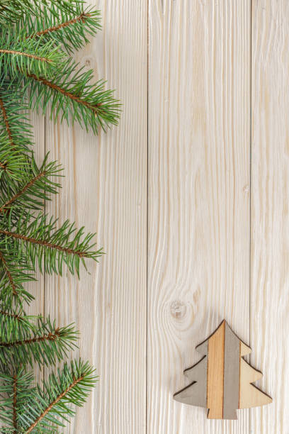 istock A small Christmas tree on white wooden background. The frame of spruce branches. The view from the top. Place for Your text. 875221204