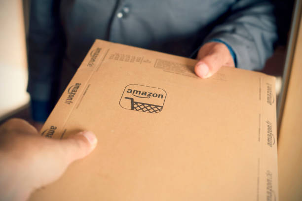 courier delivers an Amazon package to a costumer Barcelona, Spain - November 2, 2017: A courier delivers an Amazon package to a costumer. Amazon is an important worldwide online shopping company based in the United States amazon.com photos stock pictures, royalty-free photos & images