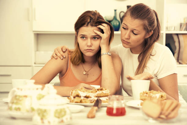 istock Female talking with young sad friend at home 875221324