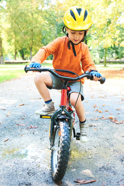 istock Boy ride a bicycle in city park 875221992