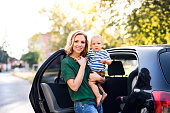 junge-mutter-mit-ihrem-kleinen-baby-jungen-durch-das-auto-stehen.jpg?b=1&s=170x170&k=20&c=hzn6JcXSRPTb4ZH59dhLGDQAi2qe-O6KJh_B1z3-9TY=