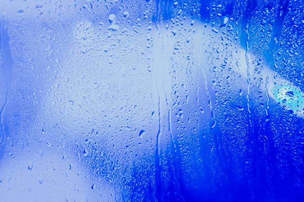 istock Drops on the glass rain blue background 875224826