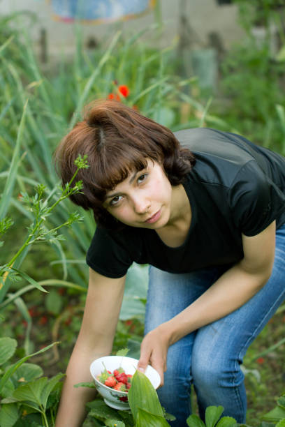 istock girl collects strawberries 875225424