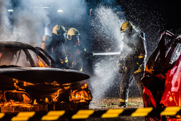 istock Firefighters spraying water near car crash 875228714