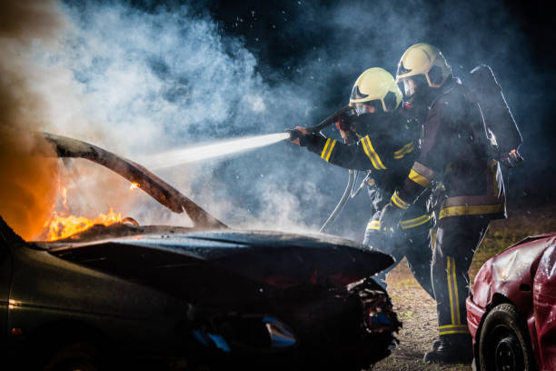 istock Firefighters spraying water on burning car 875228718