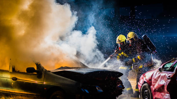 istock Firefighters spraying water on burning car 875228720
