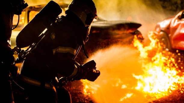 istock Firefighters spraying water on burning car 875228728