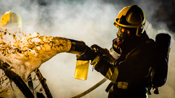 istock Firefighter spraying water on burning car 875228732