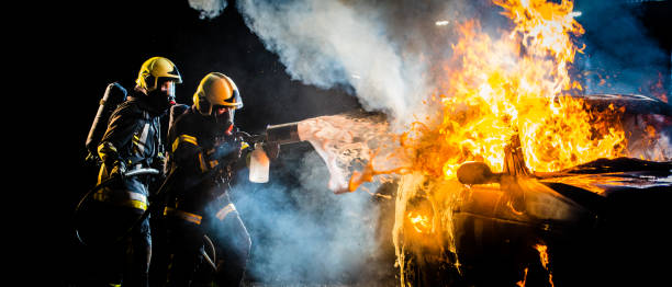 istock Firefighters spraying water on burning car 875228734